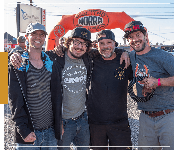 A group of men standing under an orange sign.