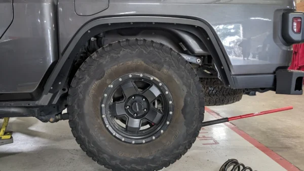 A truck tire on the ground with its wheels.