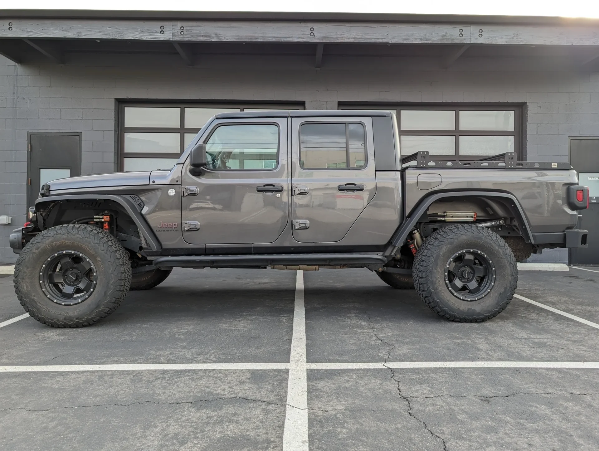 A gray truck parked in the middle of a parking lot.