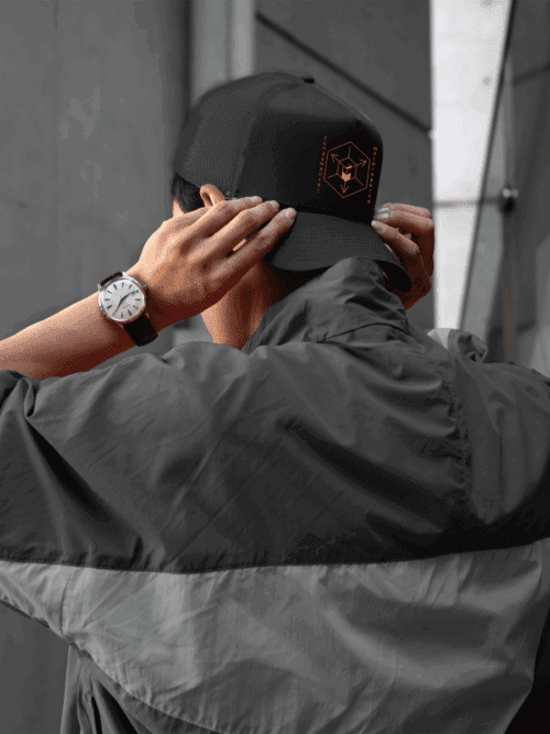 Man wearing black off-road trucker hat backwards with logo